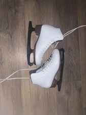 White Riedell pre-owned figure skates size 6 comes with guards and soakers.