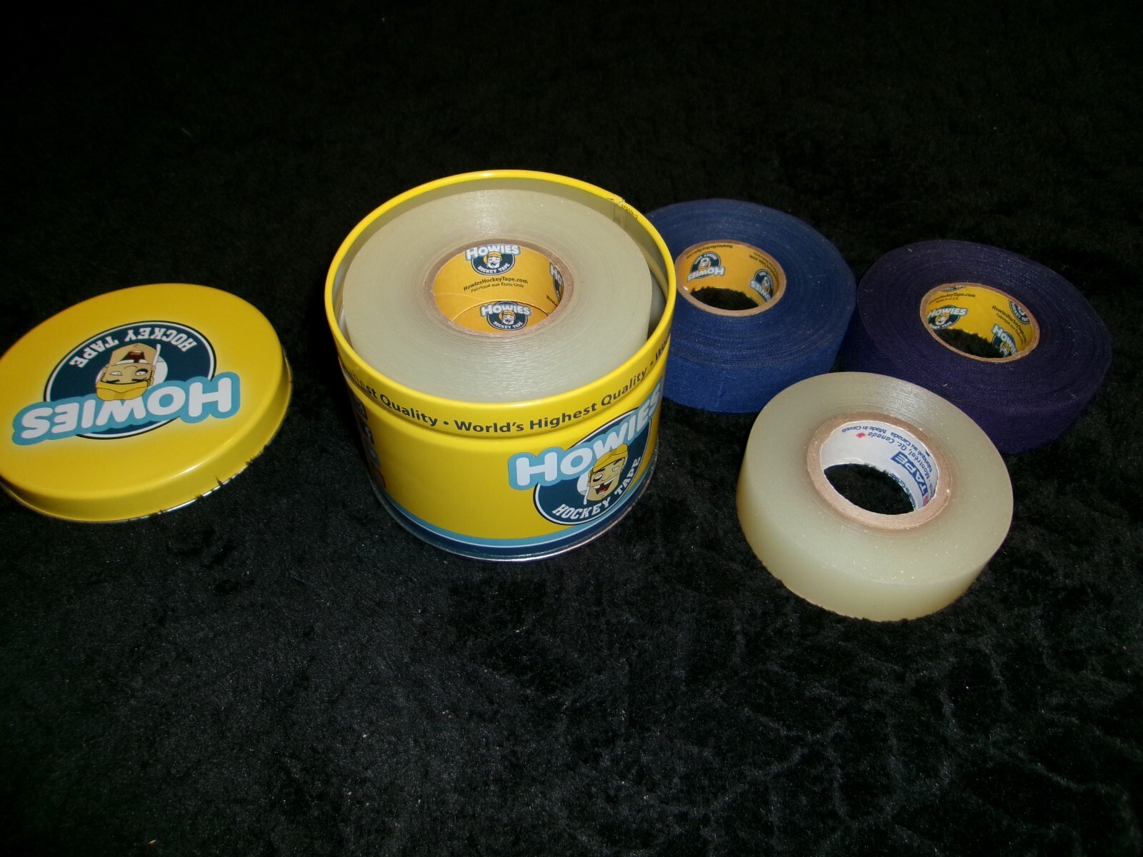 Howies Hockey Tape Tin w/ 3 clear rolls, 3/4 clear, 3/4 purple, full blue roll.