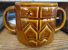 Trappist double handled brown ceramic glazed mug  raised shield with star design