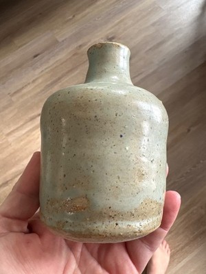 This is a handmade stoneware bud vase with a white ash glaze, likely made from l