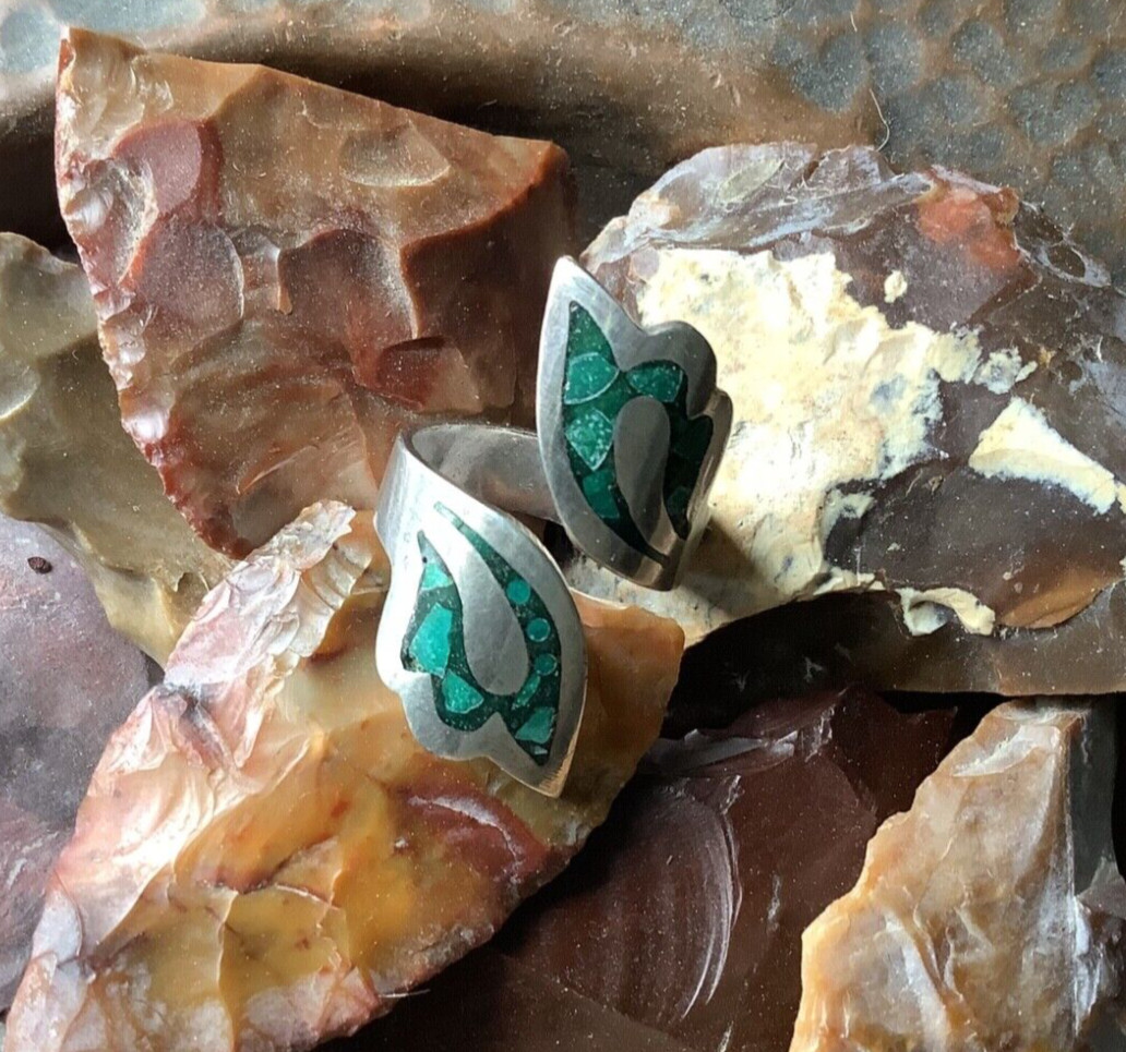 A sterling silver ring with crushed turquoise inlay, showcasing the vibrant blue stones set against the metallic band.