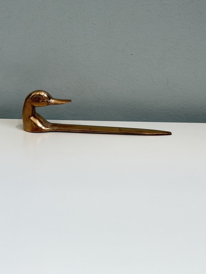 A solid brass duck letter opener is the kind of MCM desk object that feels like it belongs in a Hitchcock film's prop department — refined and slightly absurd.