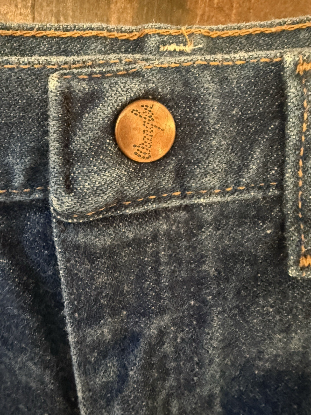 Brown leather VTG 1989 kids’ Wrangler jeans, size 7 reg, with orange stitching and front button closure.