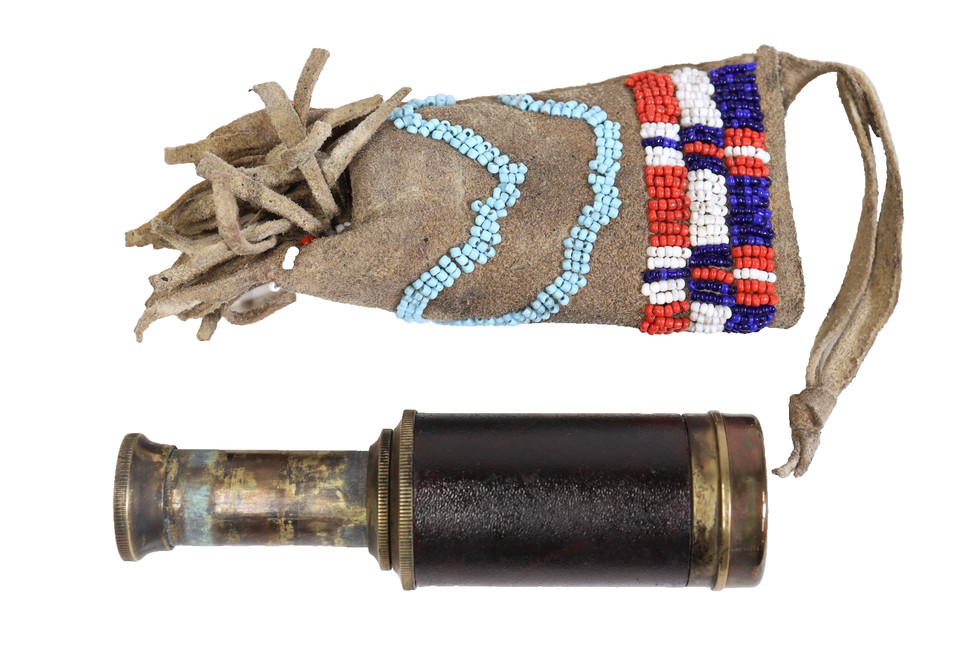 A pocket telescope paired with a handmade beaded pouch — functional antique optics meets artisan carry case.