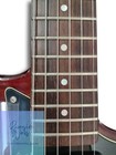 Brown electric guitar fretboard with white circular dots, small black pickguard, and “YAMAHA” logo on body.