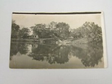 J977 postal RPPC escena lago con algún tipo de molino o negocio maderero