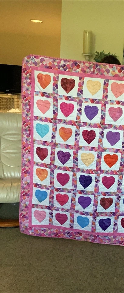 Corazones aplicados bordeados por una tela circular coordinada en un edredón hecho a mano Foto 2 de 4