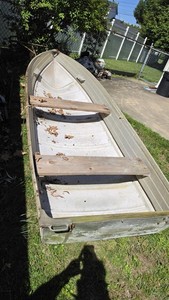 Small Light Green Aluminum Open-Top Canoe with Wooden Bench Seats
