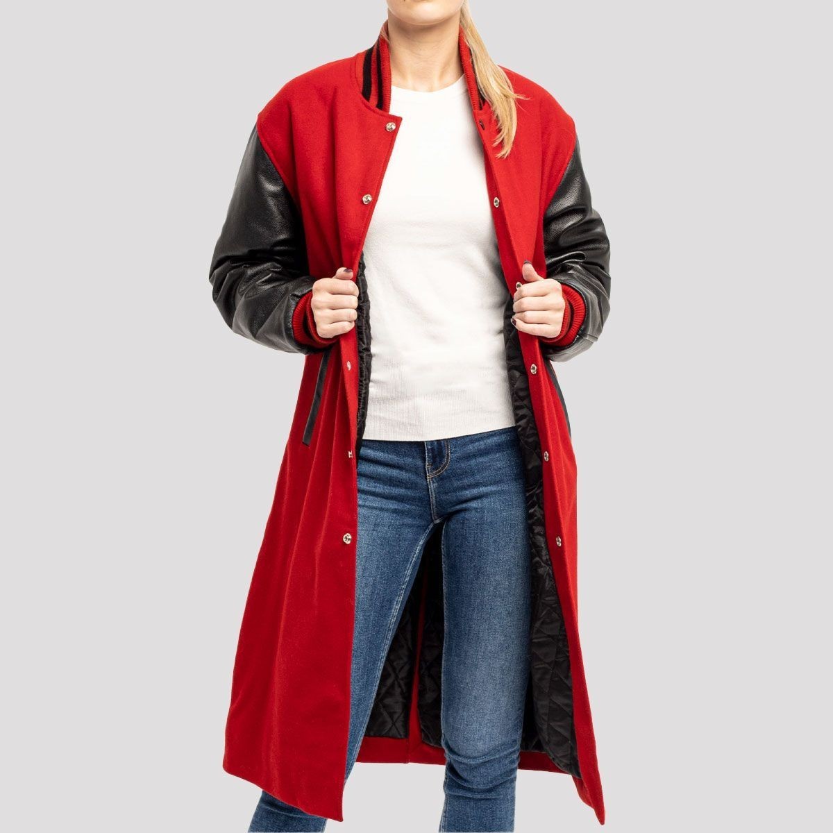 Scarlet red wool longline varsity coat with black leather sleeves, worn open over jeans and a white top.
