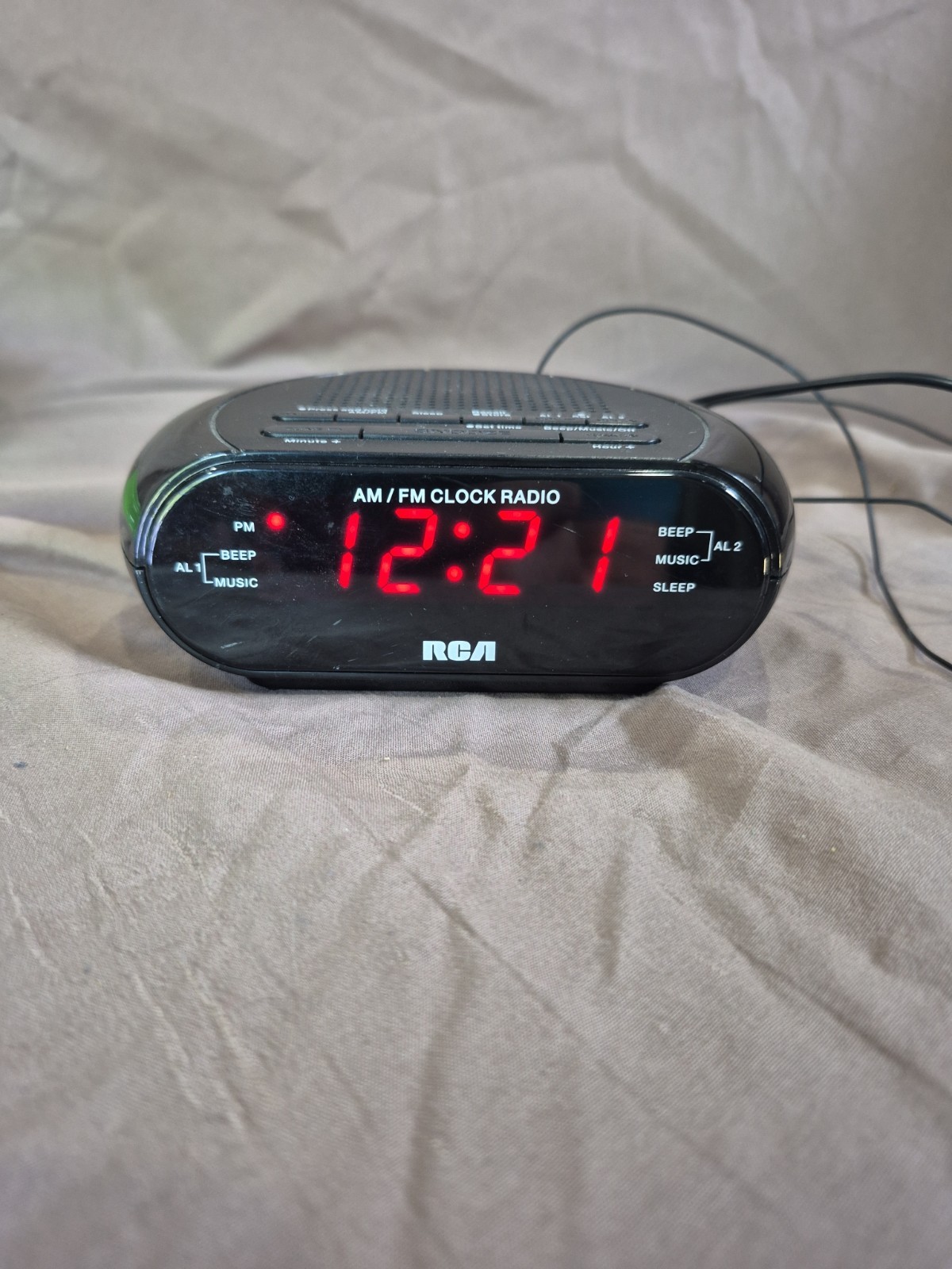 RCA RC205 digital AM/FM alarm clock radio in black with a red LED display