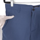 Blue slim-fit Theory men’s dress pants with front button closure, belt loops, and subtle textured fabric on hanger.