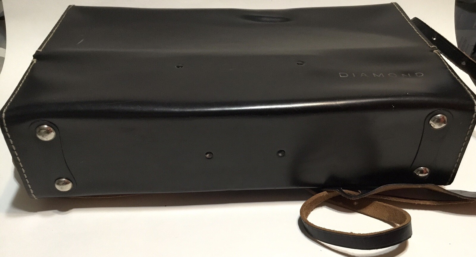 Black leather shoulder bag with white Diamond logo, two silver rivets, and brown leather strap on side.