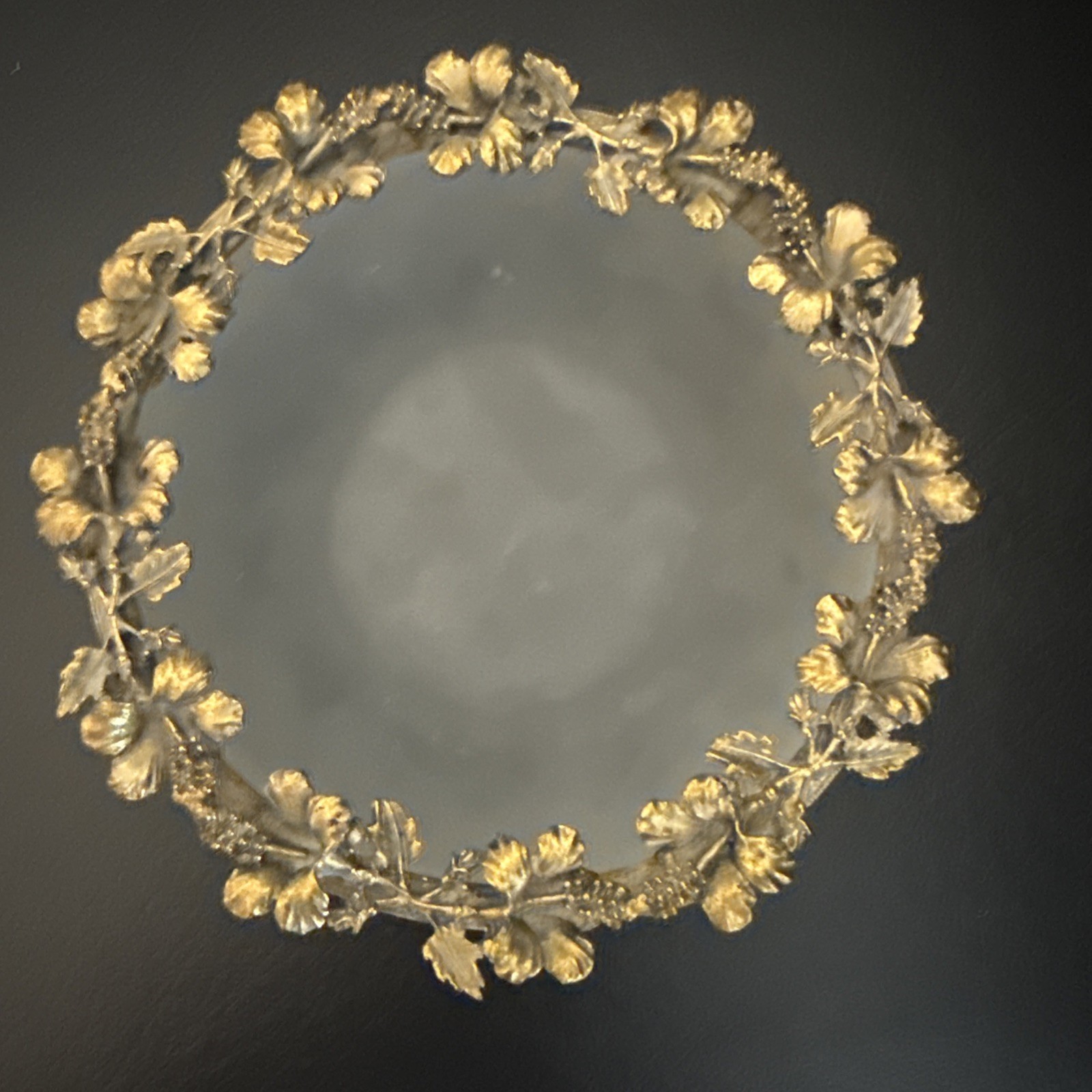 Antique Frosted Round Dish Wth Flowers And Leafs Decorating All Around it.