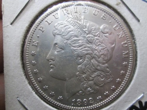US 1892 CC MORGAN DOLLAR COIN IN ABOUT UNCIRCULATED CONDITION