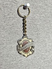 Vintage souvenir keychain featuring the early emblem of Oldsmobile 