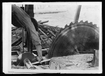 Sawing, Lumber camp. Dangerous method of shifting belt on circular saw