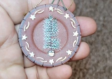 A miniature decorative plate made of red clay from Ragon House.