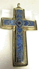 This cross pendant made of lapis lazuli and a metal alloy silver-toned metal.