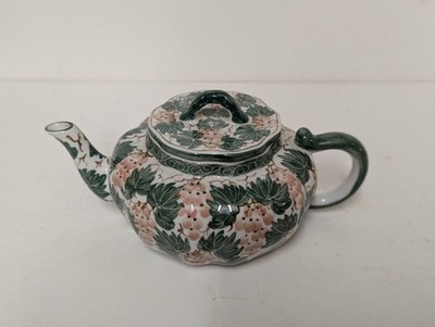Eine kleine Keramik-Teekanne mit Stachelbeerenmotiv, handbemalt in Thailand