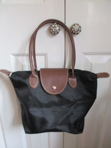 Black fabric, tan faux leather trim/handles, plastic lined, bucket/hand bag