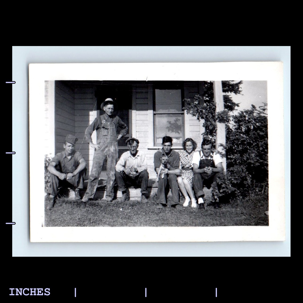 Vintage photo of a man woman and dog standing outside a house