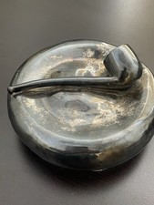 Vintage metal pipe ashtray with integrated pipe rest.