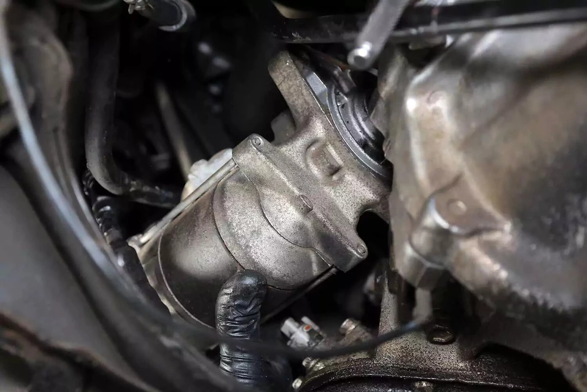 Removing the starter from the engine.