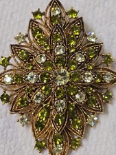 Vintage Gold Tone Starburst Brooch Features Olive Green Clear Rhinestones