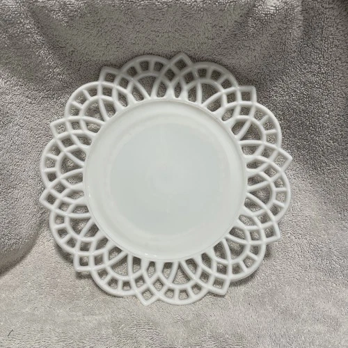 Vintage white milk glass decorative plate with a lace-like border.