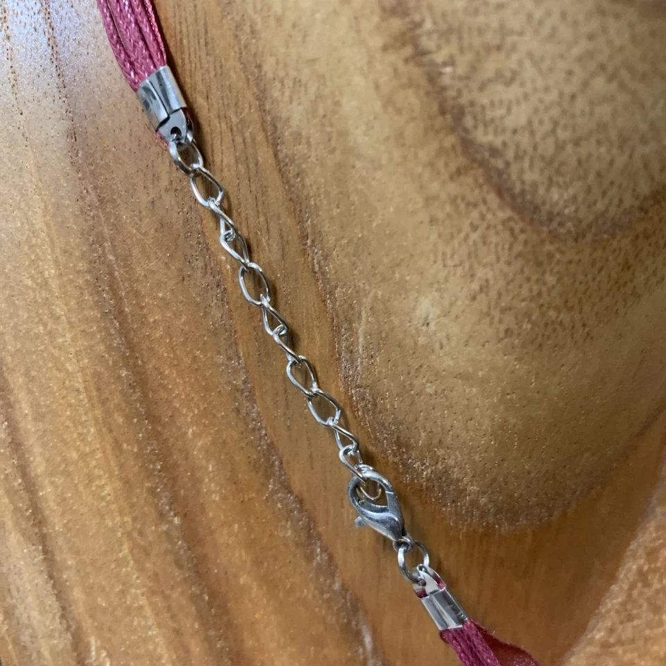 Collar/garra de cerámica blanca con brotes verdes y brillo en una cinta granate Foto 3 de 4