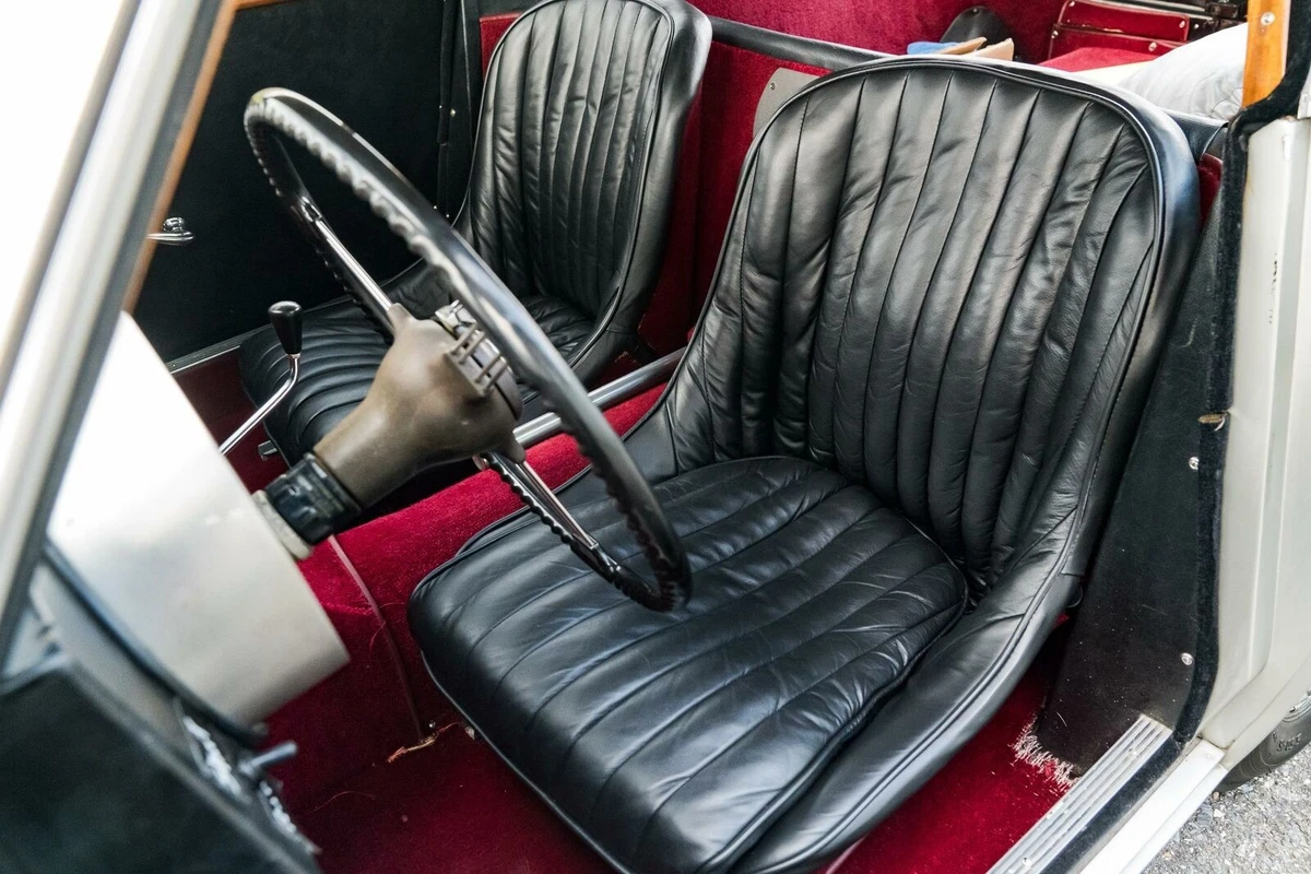 Traditional British black leather contrasts with bright red carpets in the AC Aceca.