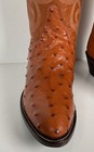Brown ostrich quill women's cowboy boots with pointed toes and dark brown soles, featuring embossed Western flame and swirl patterns.