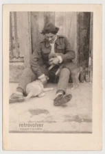 Amid the Chaos of WWII - Young Soldier's Joyful Moment with Two Playful Puppies