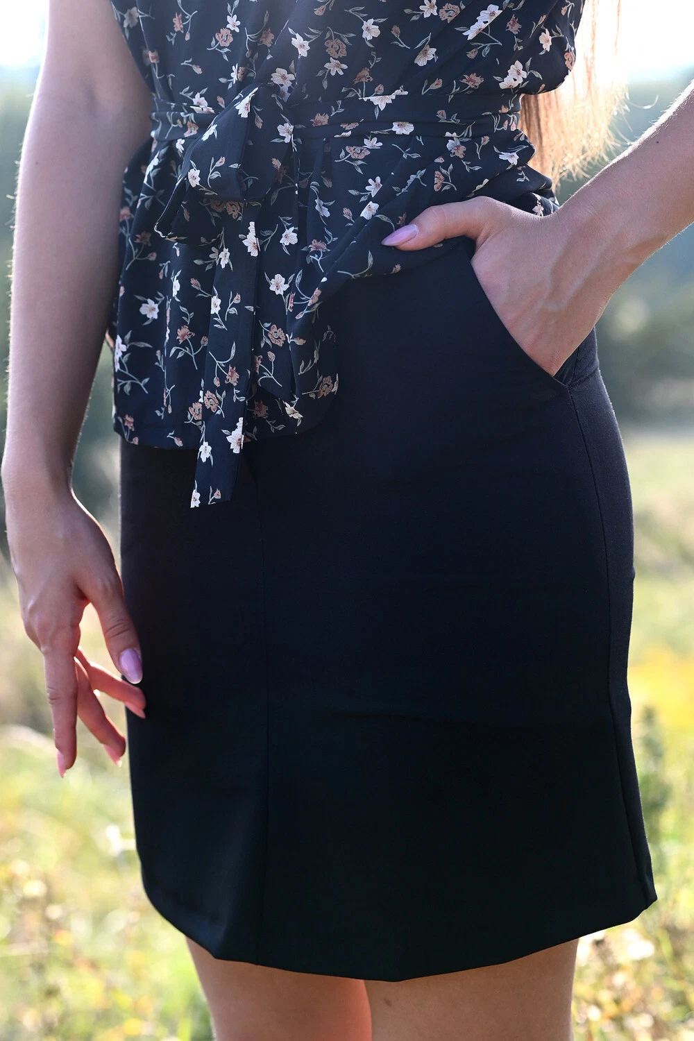 The skirt is black, short with a fastener in front