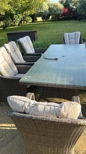 large rattan garden table with 8 chairs and cushions