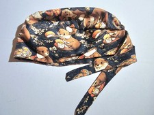 whimsical tie-back surgical scrub cap featuring a dark background covered in...