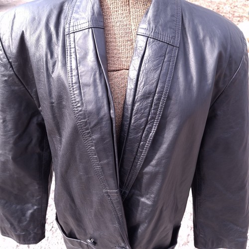 Black leather trench coat with wide shoulder panels, double-breasted buttons, and textured rear seams.