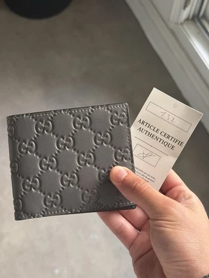 Gucci portefeuille homme bifold pliable cuir gris motif logo GG embossé - Photo 1/4