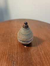 A vintage wooden spinning top with a metal tip, likely by Duncan