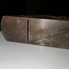 Worn smooth bottom of a dark metal Blackhawk C557MP wood hand plane with visible scratches and textured surface.