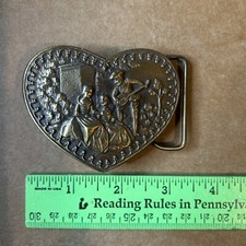 vintage Adezy heart-shaped belt buckle featuring a courting scene in relief