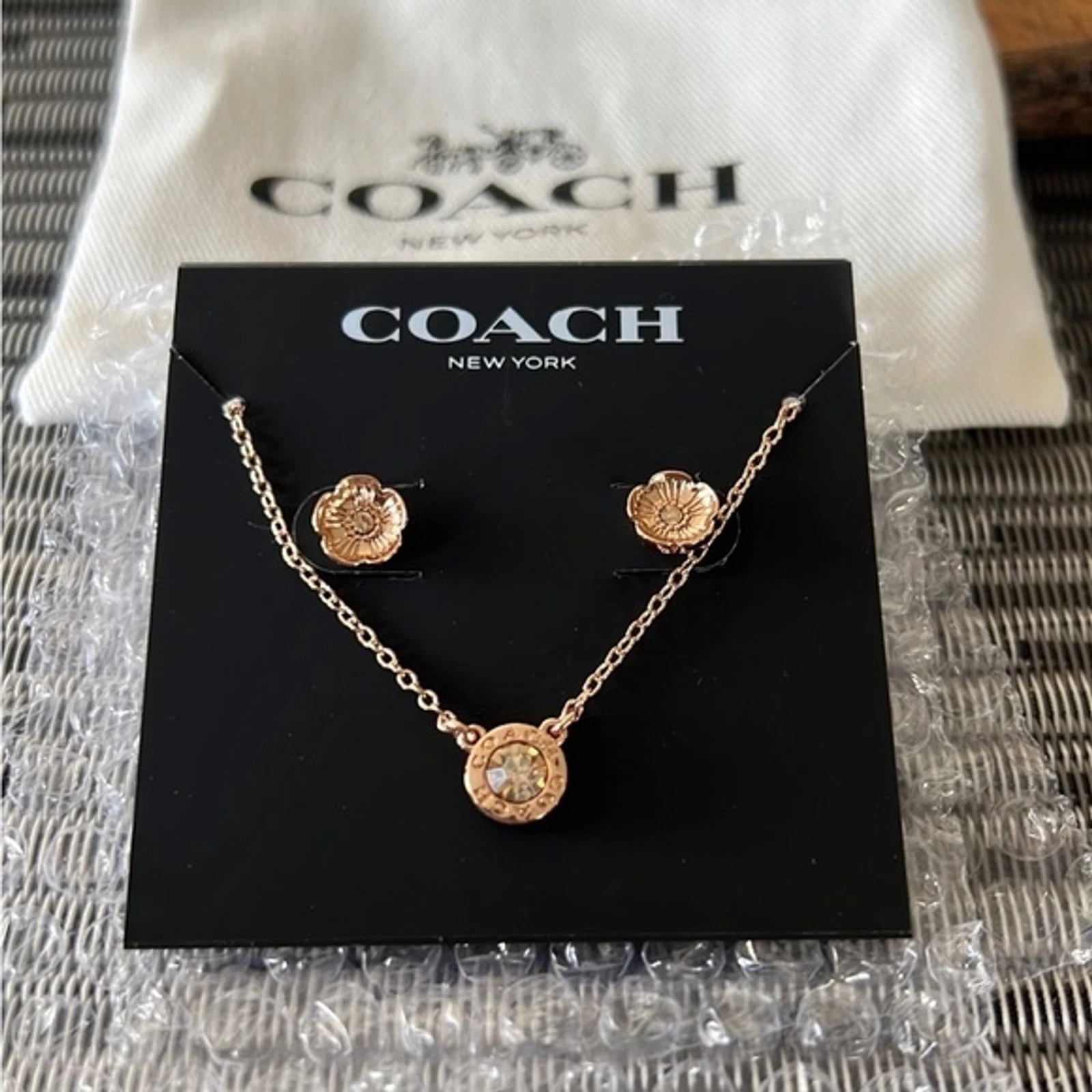 Nuovissimo set orecchini e collana Coach fiori oro rosa con sacchetto