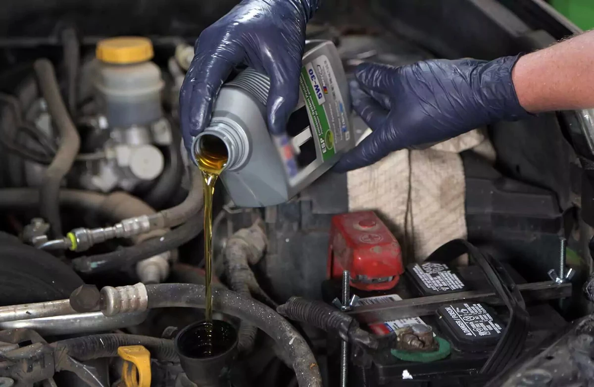 Pouring oil into an engine.