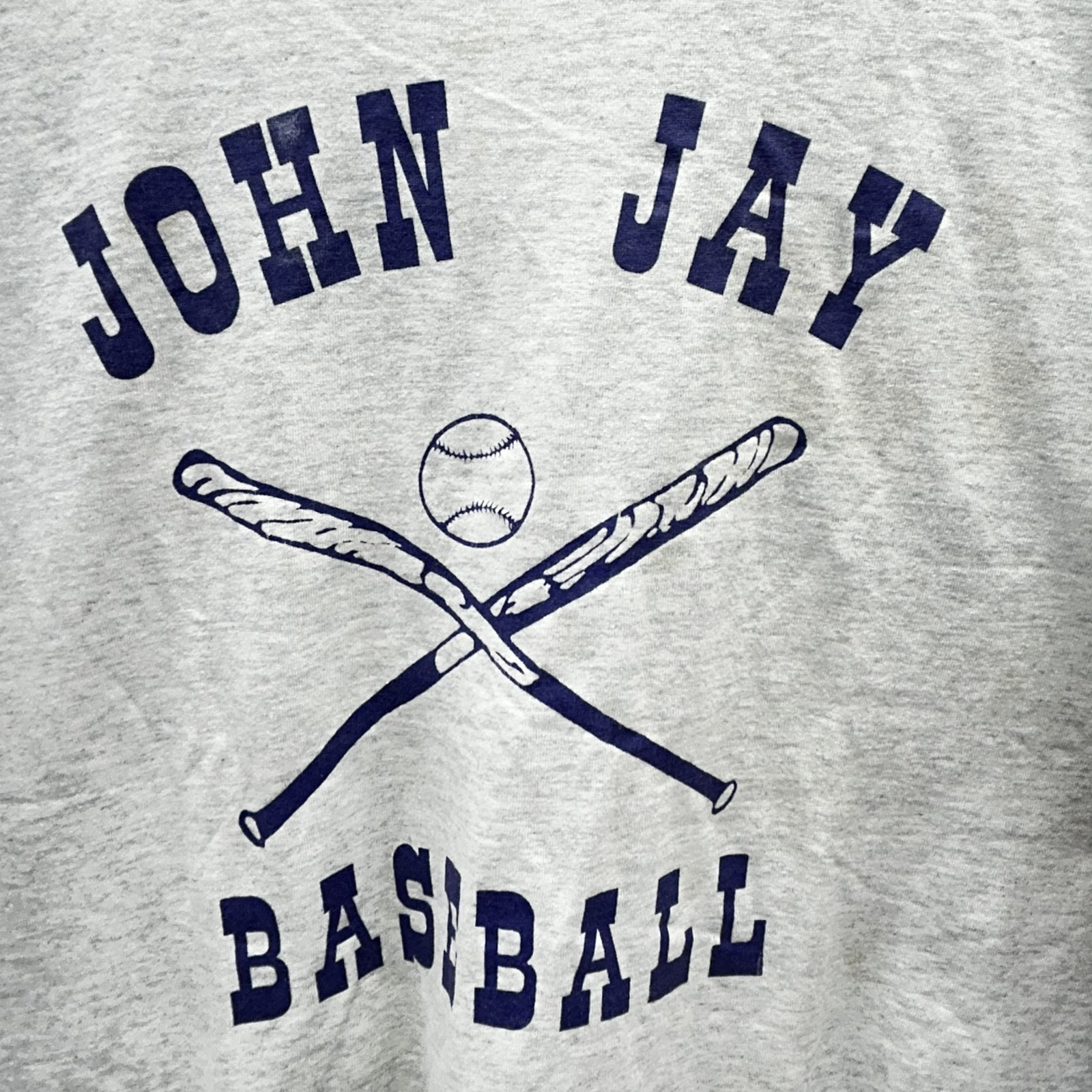 Gray long-sleeve baseball t-shirt with navy “John Jay Best XL” text and crossed baseball bat and softball graphic.