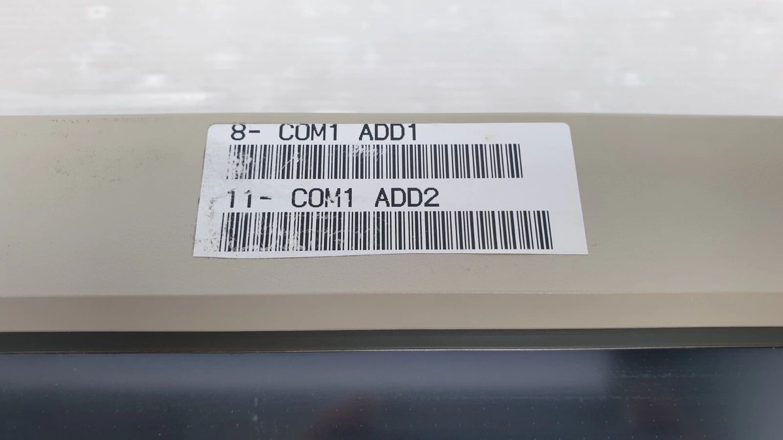 Close-up of the COM1 ADD1 / COM1 ADD2 label on the STC 12-T front bezel