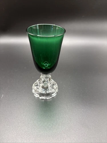 Emerald green depression glass cordial with a clear faceted stem.