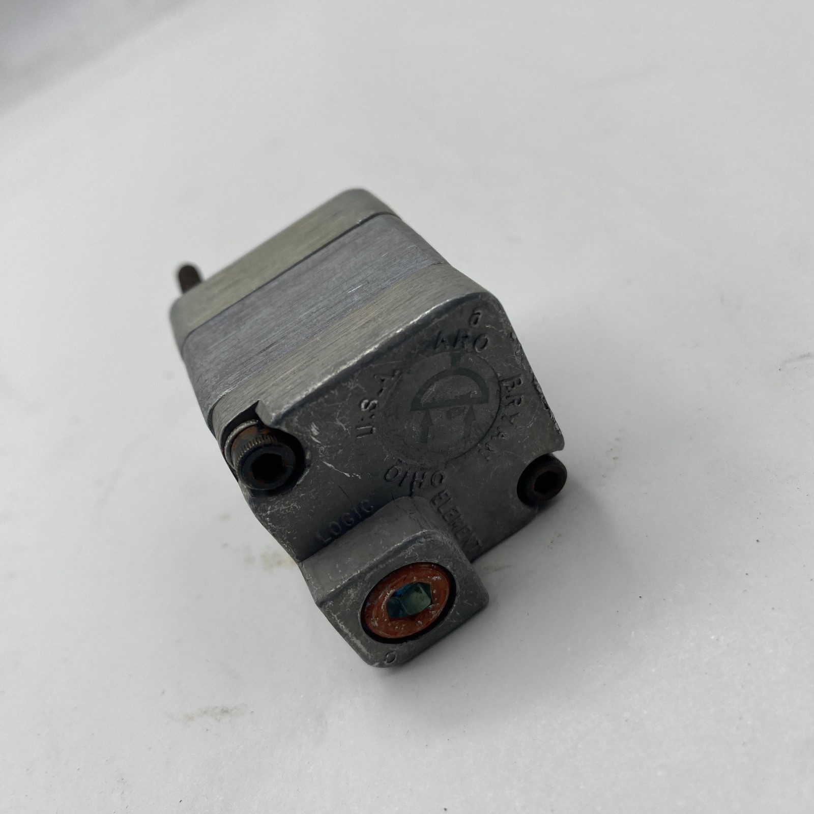 Silver ARO FLUID POWER 59111 PNEUMATIC LOGIC ELEMENT with black printed specifications and brass fitting, made in USA.