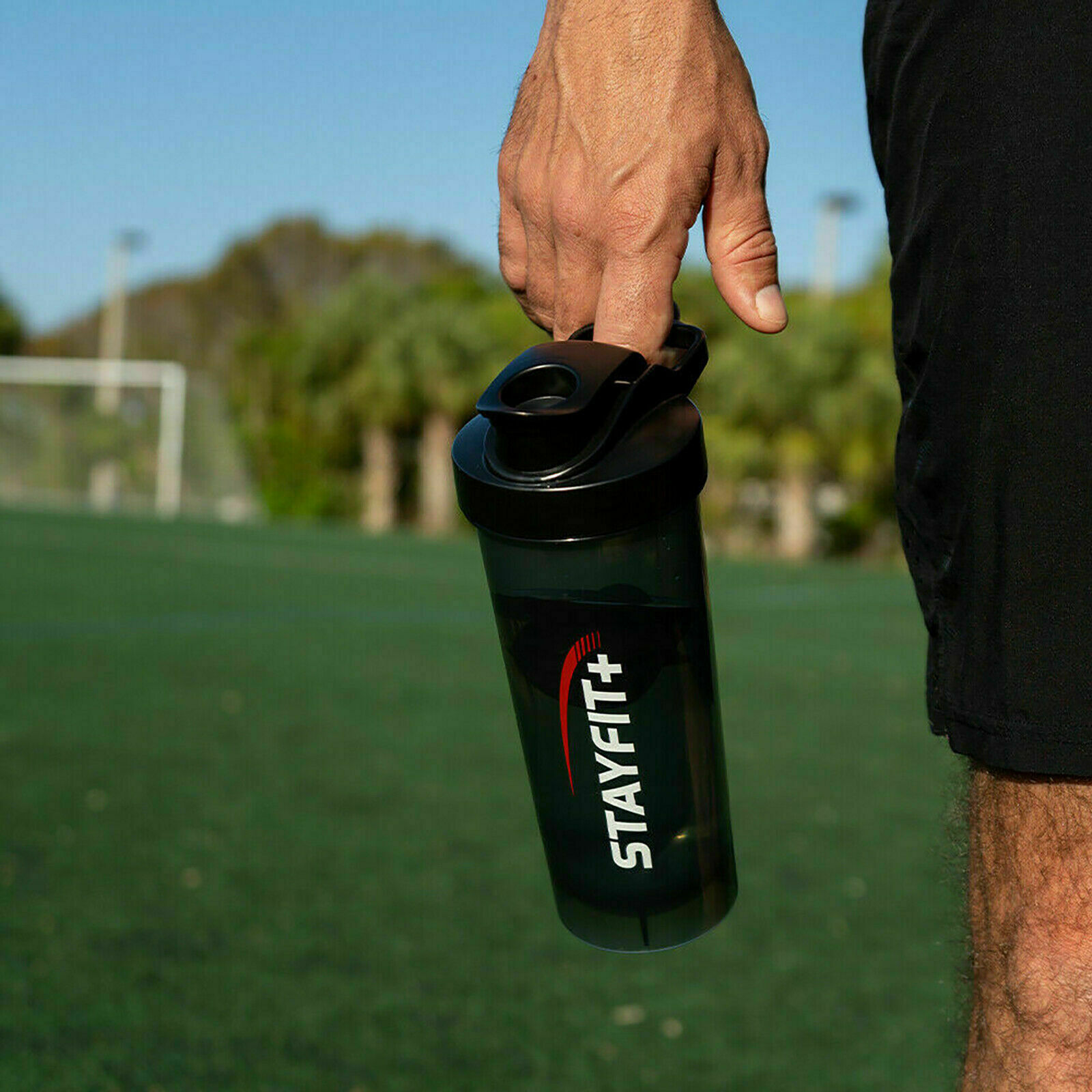 Picture of a black protein bottle being held by someone