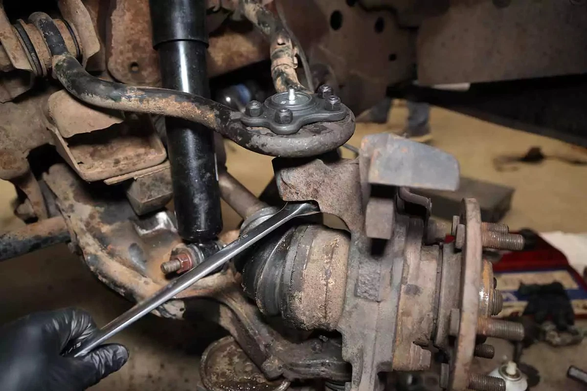 A mechanic uses a crowfoot wrench to tighten the new castle nut.
