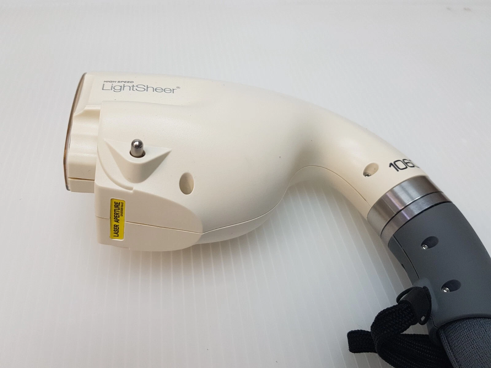 LightSheer 1060 handpiece head with LASER APERTURE label and lanyard